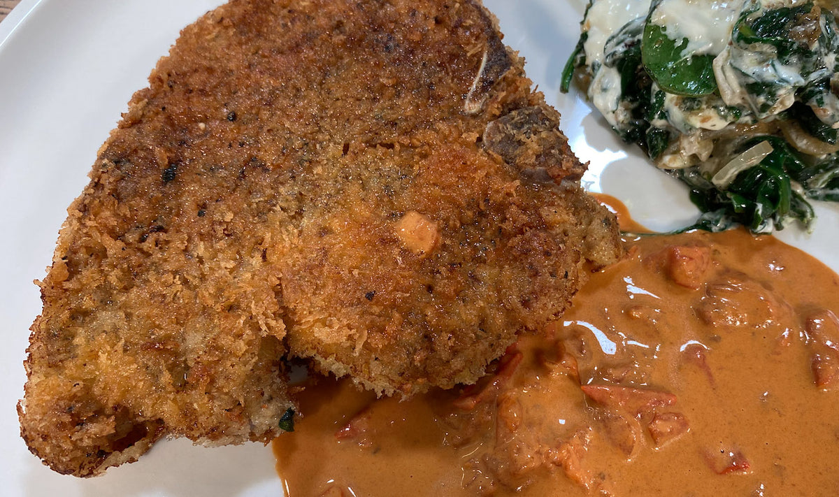 Paniertes Schweinekotelett mit Soja-Tomatencreme und Spinat
