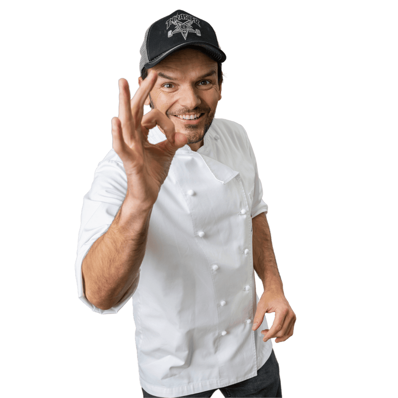 Steffen Henssler als Koch in weisser Jacke mit OK Handzeichen
